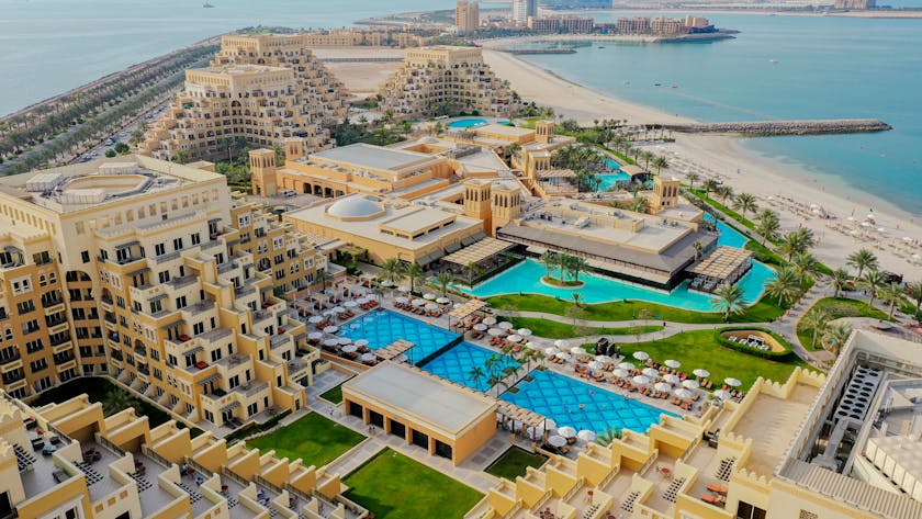 Aerial view of luxury beachfront properties in Ras Al Khaimah, showcasing resort-style apartments and villas near the shoreline, ideal for those seeking property for sale in Ras Al Khaimah with scenic sea views and upscale amenities.