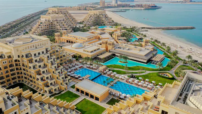 Aerial view of luxury beachfront properties in Ras Al Khaimah, showcasing resort-style apartments and villas near the shoreline, ideal for those seeking property for sale in Ras Al Khaimah with scenic sea views and upscale amenities.