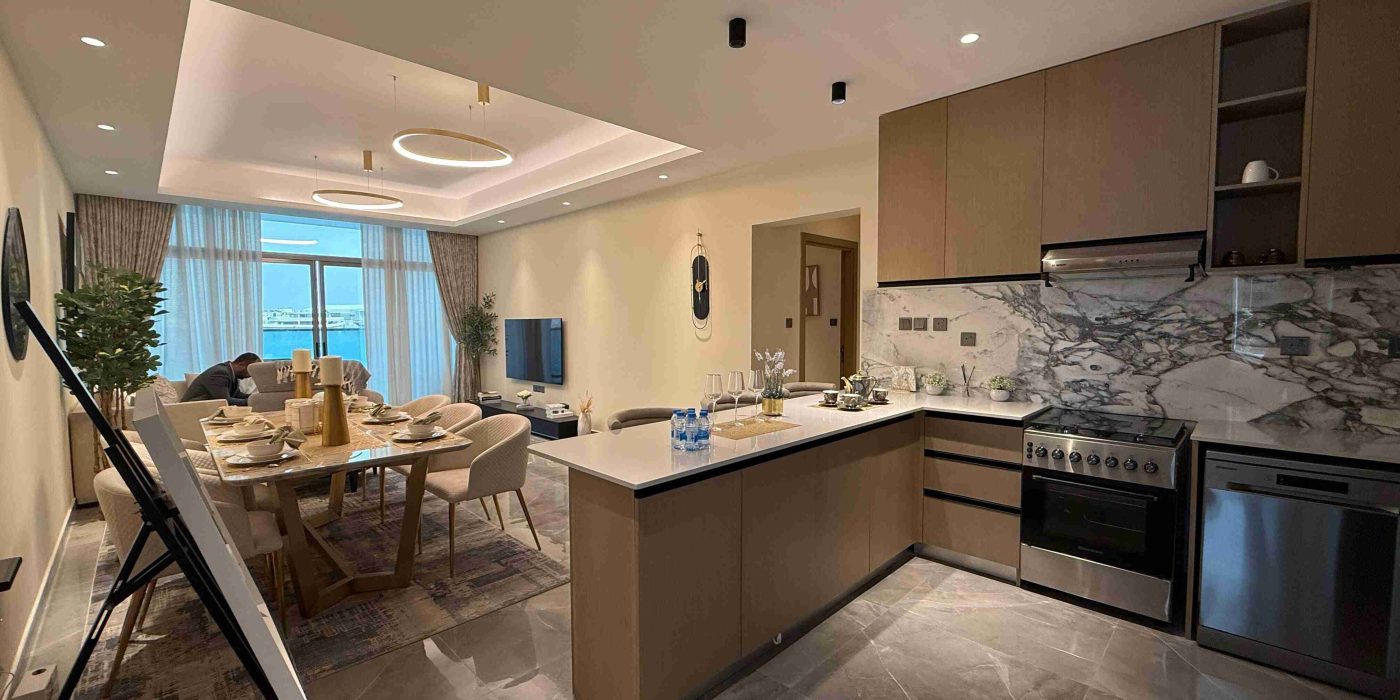 Modern open-plan kitchen and dining area in an off-plan vs. ready-to-move-in property in UAE, featuring sleek cabinetry and marble flooring.