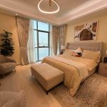 Luxuriously furnished bedroom in an off-plan apartment in Ajman, featuring elegant decor, natural lighting, and a serene ambiance