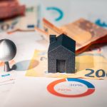 Dubai real estate market trends concept with financial charts, euro banknotes, and miniature house model, symbolizing property investment and market analysis