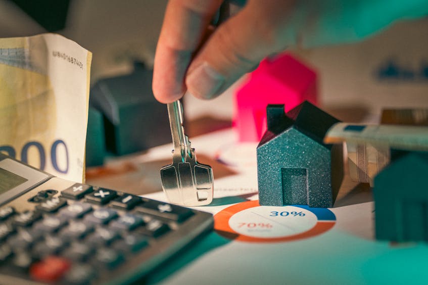 2 house models, key, a calculator, and a percentage of financing a house shows the buyer choose one of the developer vs financing options in ajman to buy property